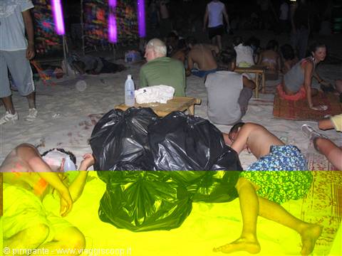 Young people sleeping on the sand at night beside a black bag