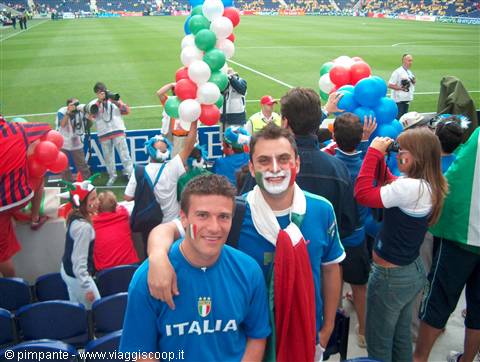 Italian fans with painted faces and tricolor balloons inside the stadium