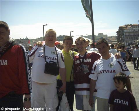 Fans in Latvija jerseys pose together on Porto's crowded riverside