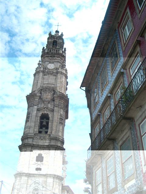 Granite Clérigos Tower beside azulejo-tiled houses under cloudy sky
