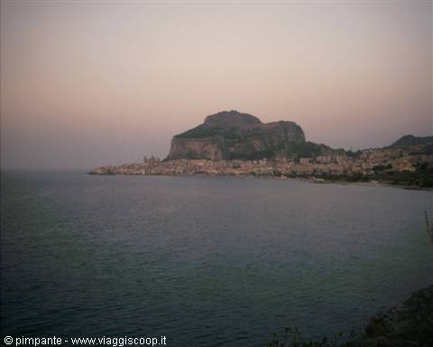 Cefalù: town and Rocca rock above the sea at dusk