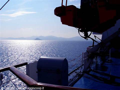 Ferry deck with red lifeboat, sparkling sea and islands on the horizon