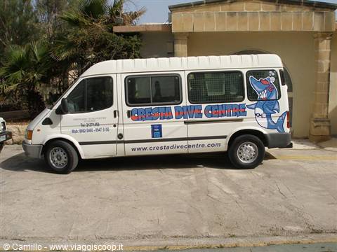 White Cresta Dive Centre van with painted shark, parked outside a building