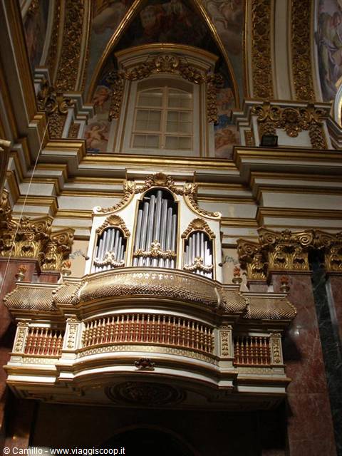 Gilded pipe organ balcony inside a baroque frescoed church
