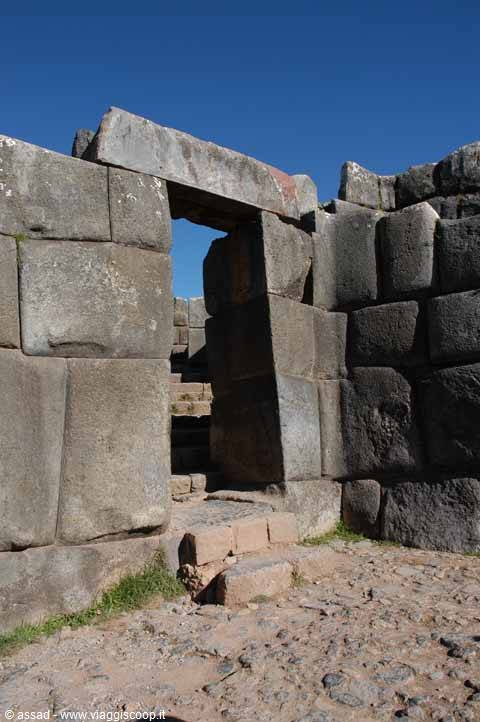 Trapezoidal Inca stone doorway, polygonal walls, blue sky at Sacsayhuamán