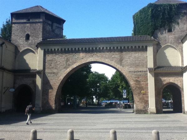 Pedestrian walking through Sendlinger Tor, medieval brick gate in Munich