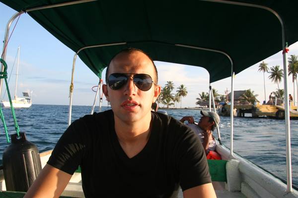 Tourist in sunglasses on a shaded boat near palm trees