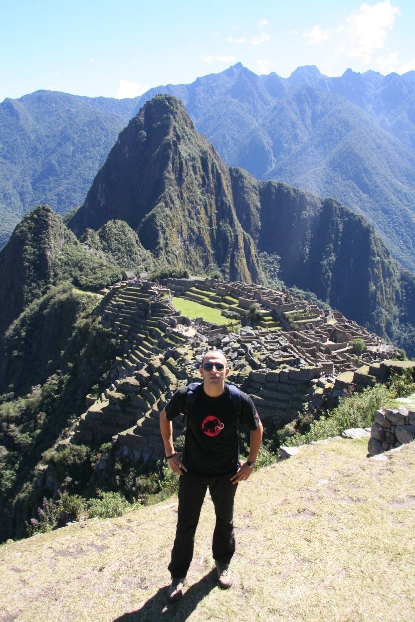 Turista in piedi sopra le terrazze e le rovine di Machu Picchu