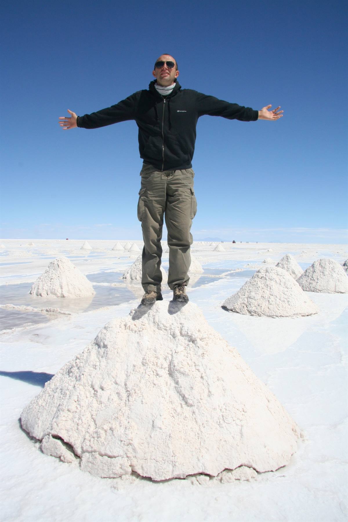 Uomo in piedi su un mucchio di sale nel Salar de Uyuni