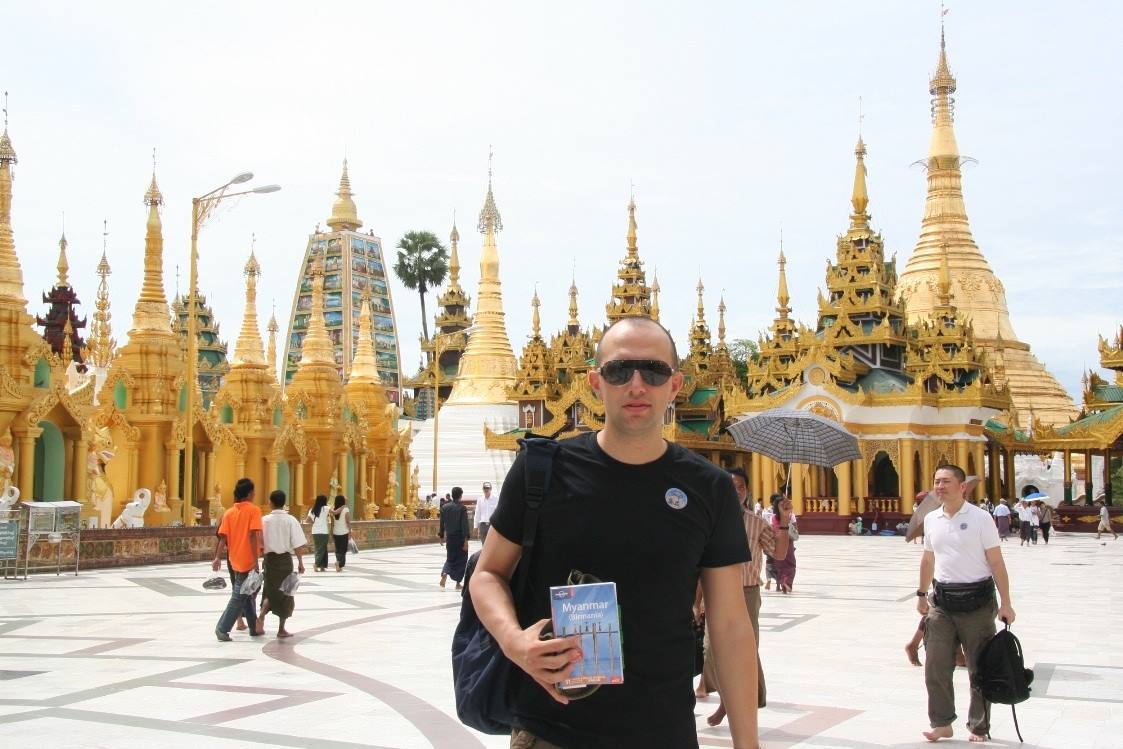 Turista con mappa e zaino tra le pagode dorate della Shwedagon Paya