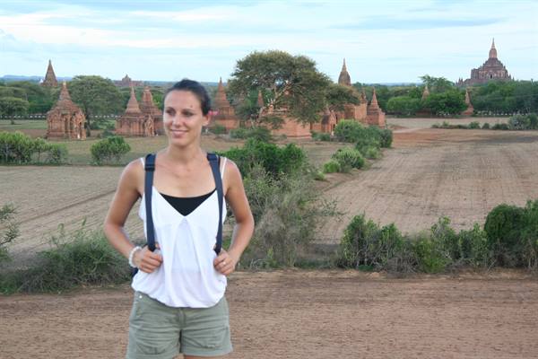 Backpacker smiling among the brick temples of Bagan