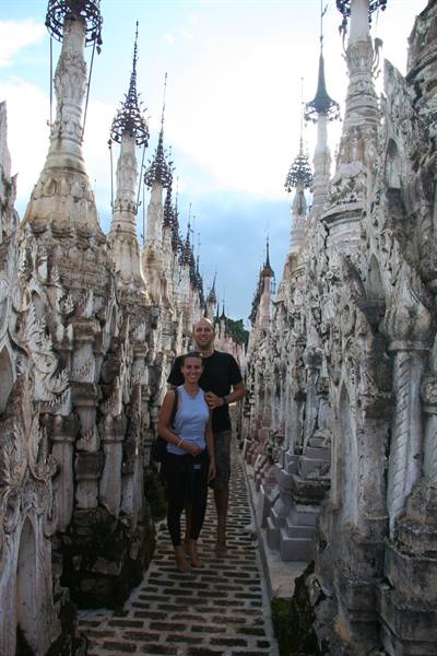 Couple walking among rows of carved white stupas at Kakku