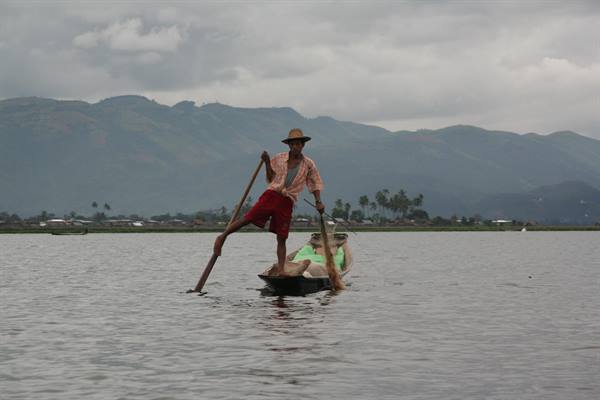 Fisherman rowing with his leg on a canoe at Inle Lake