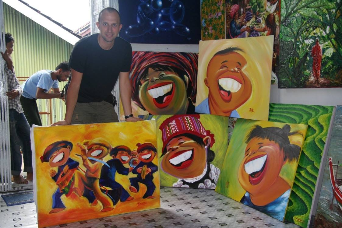 Visitatore tra dipinti colorati di volti sorridenti in una galleria d'arte
