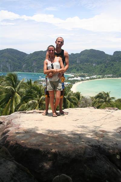 Couple embracing on the viewpoint rock, turquoise bays and palms at Ko Phi Phi