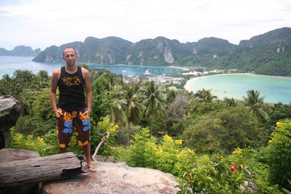 Tourist in tank top at Ko Phi Phi viewpoint, turquoise bay and palm trees