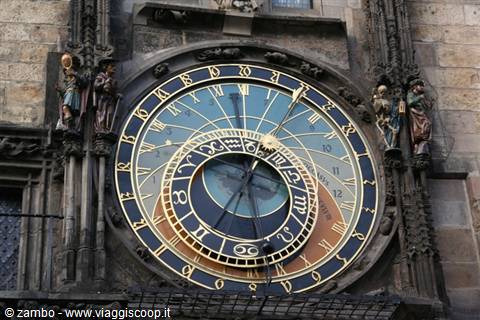 Medieval astronomical clock with blue and golden dial on stone facade, Prague