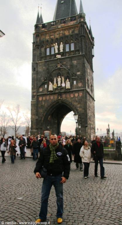 Tourist in black jacket beneath Prague's Old Town Bridge Tower