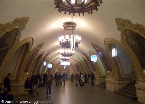 Moscow metro station, golden mosaics and chandeliers light waiting passengers