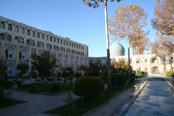Abbasi Hotel courtyard in Esfahan: reflecting pool, autumn trees and turquoise dome