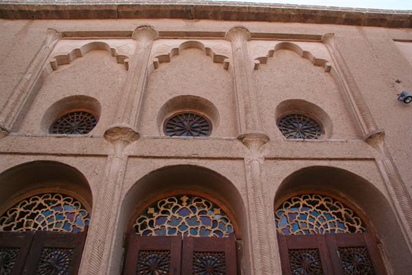 Brick facade with arches and geometric stained glass, Yazd