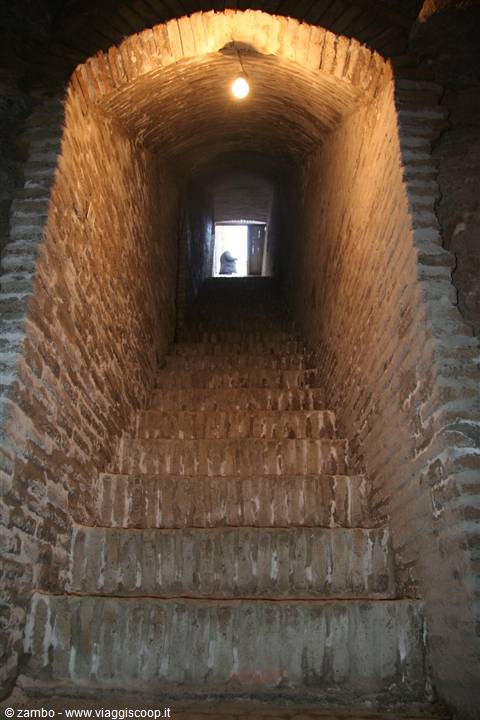 Brick staircase under vaulted passage lit by bulb, Yazd