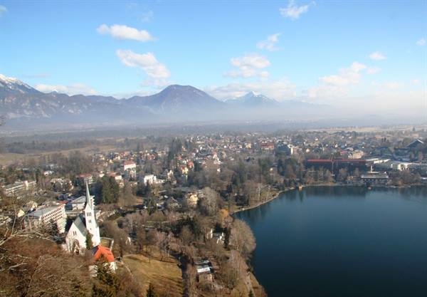 White church and lake at Bled with misty mountains behind