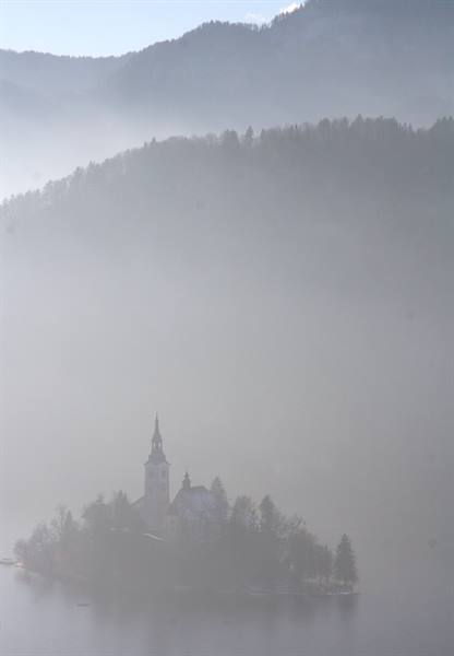 Bled island church emerging from the fog on the lake