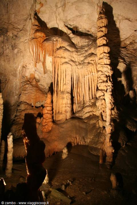 Limestone stalactites and stalagmites illuminated inside a cave