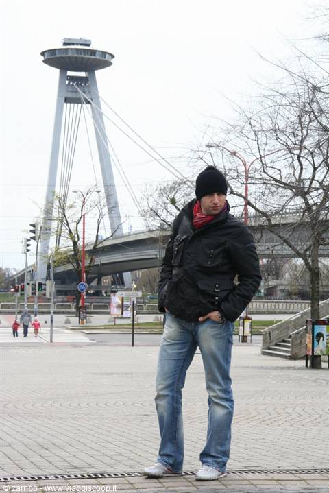 Tourist in front of the UFO Bridge in Bratislava on a grey day