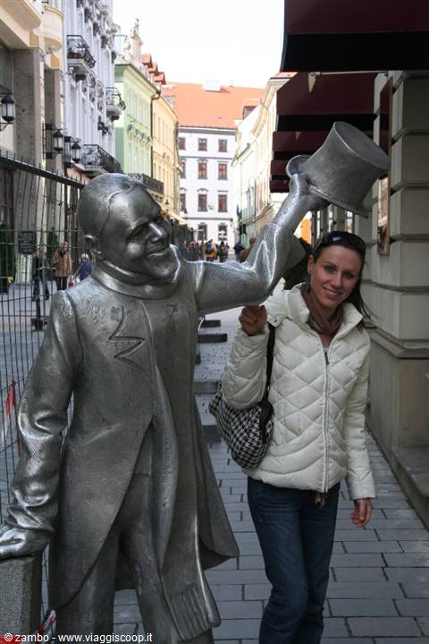 Tourist next to Schöne Náci statue raising his top hat, Bratislava
