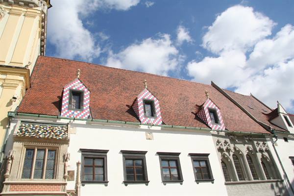 Checkerboard dormer windows on the red roofs of Bratislava's Old Town Hall