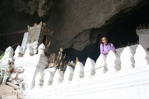 Tourist inside a cave with golden Buddha statues and white stupas