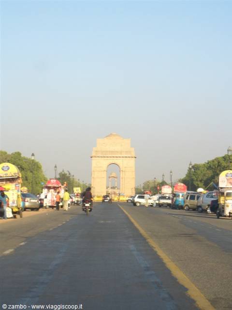 India Gate in Delhi, road with cars and rickshaws under clear sky