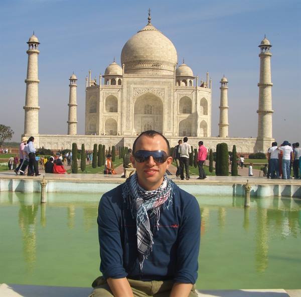Tourist sitting in front of the Taj Mahal fountain in Agra