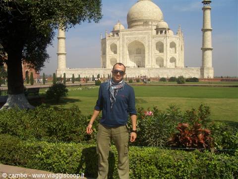 Tourist standing on lawns in front of the white marble Taj Mahal, Agra