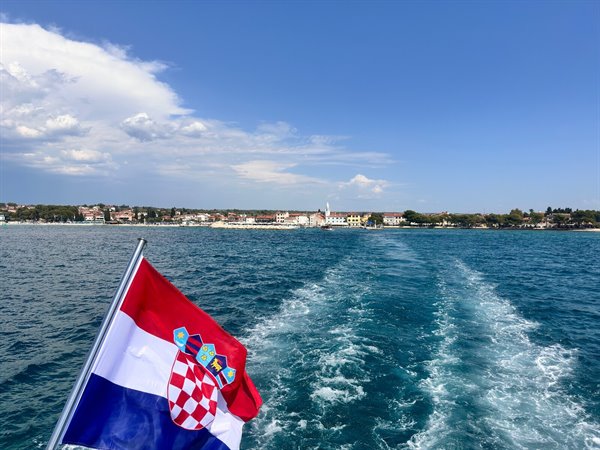 Farewell to the Istrian coast: the ferry's wake and the Croatian flag in the wind.