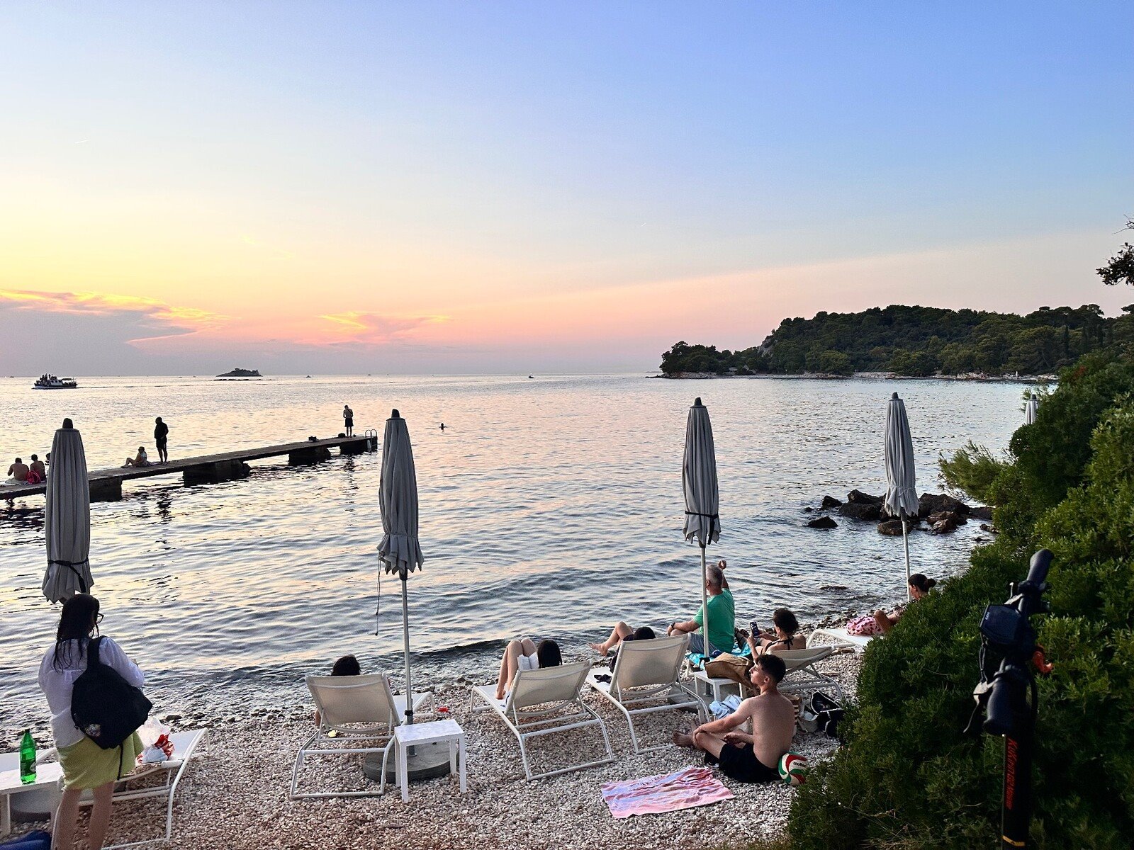 Tramonto dorato sulla spiaggetta di Ciolo, relax e mare calmo.