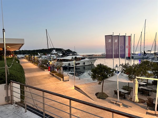 Sunset over the port of Rovinj, among boats and lights turning on