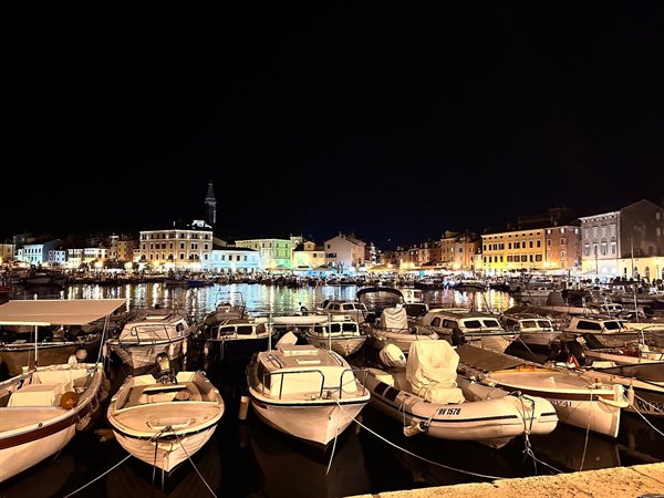The port of Rovinj at night: dancing lights on the water and sleeping boats.