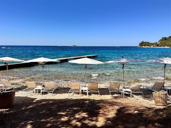 Under the umbrella in front of the turquoise sea, time has stood still.