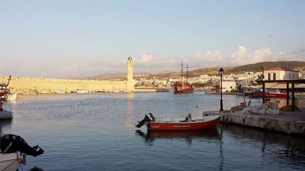 The Venetian lighthouse of Rethymno at sunset: the harbour is silent, all is golden.