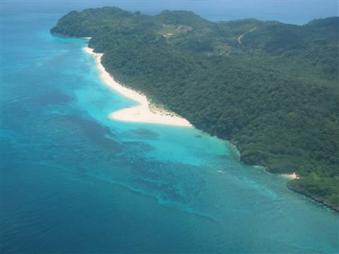 Tropical island with white sand beach, turquoise water and green forest