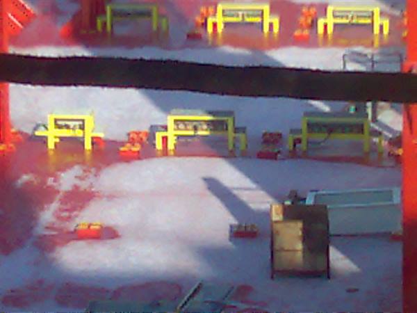 Yellow equipment on red platform under sunlight, blurry shot