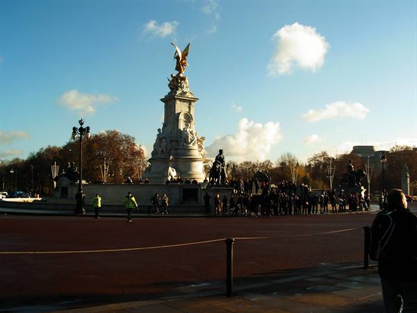 Crowds gather at the Victoria Memorial outside Buckingham Palace under blue sky