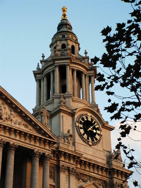 St Paul's Cathedral bell tower in London, golden clock, warm morning light