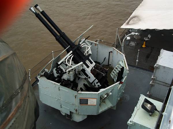 Twin grey anti-aircraft gun mounted on a warship deck