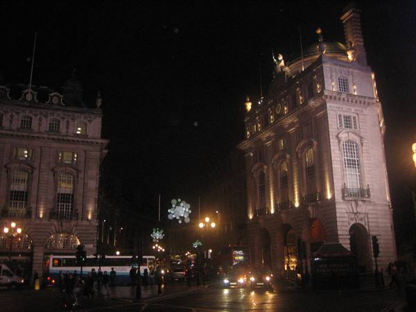 Piccadilly Circus at night, illuminated buildings, buses and cars in traffic