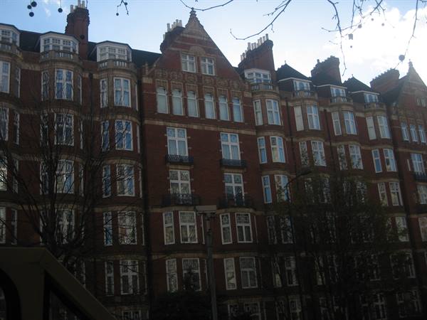 Victorian red-brick mansion with bay windows and tall chimneys