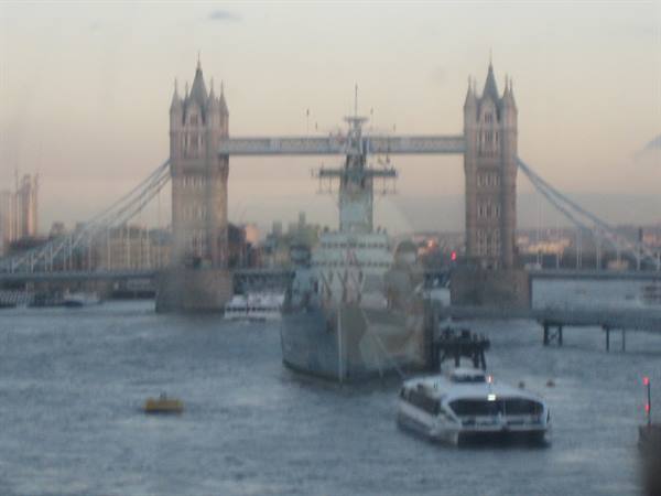 HMS Belfast cruiser and riverboat on the Thames before Tower Bridge